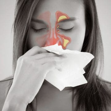 Woman blowing in tissue