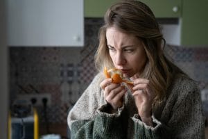 Woman trying to smell an orange
