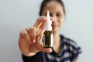 woman showing a bottle of nasal spray