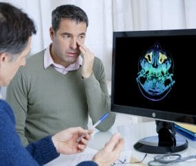 Doctor reviewing CT Scan images with patient with sinusitis