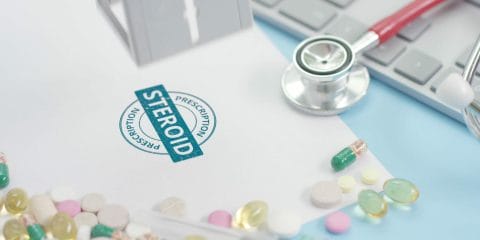 Steroid prescription stamp surrounded by pills to help inflammation