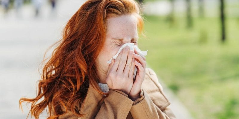 Woman with sinusitis blowing her nose