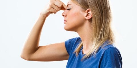 Young woman holding nose with sinusitis and sinus pain